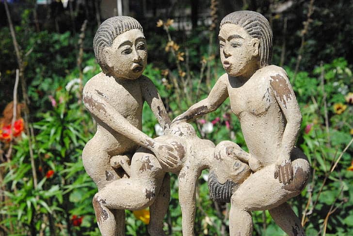 A statue depicting orgy threesome scene with two men and one woman